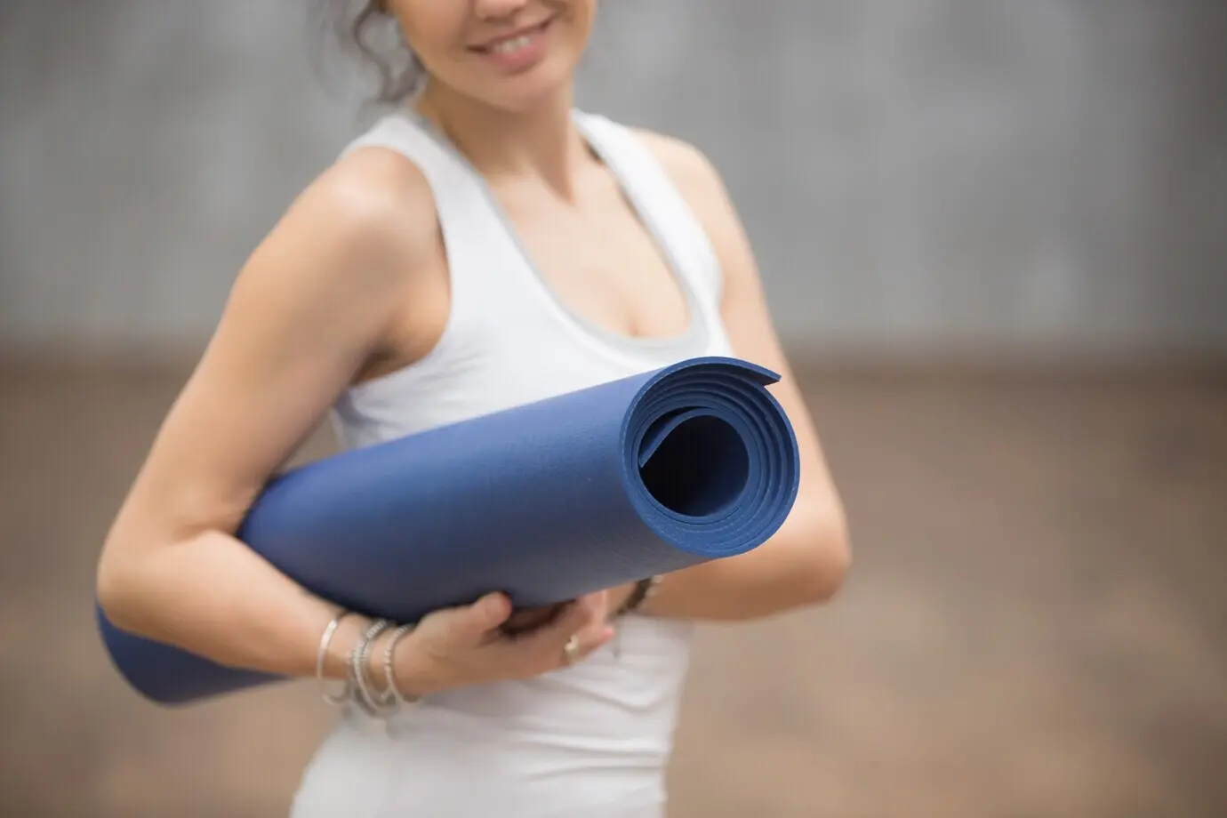 Close-up of a happy, beautiful female yogi holding her mat